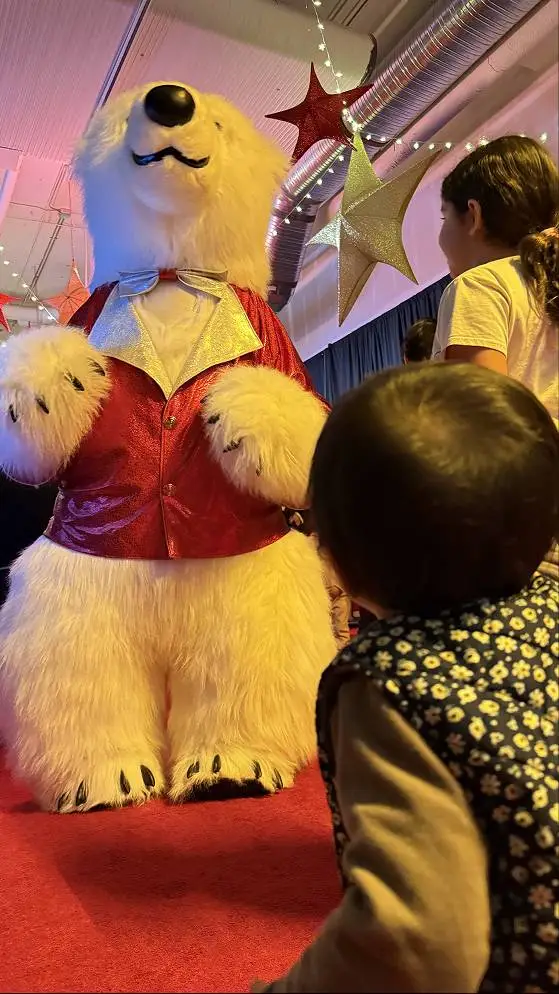 Child watching a polar bear mascot