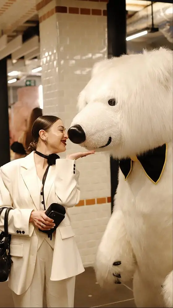 Woman interacting with polar bear mascot at a stylish indoor event in Vancouver