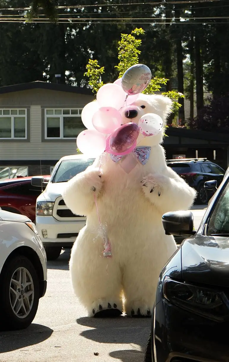 Child receiving helium ballons from a giant polar bear mascot at a kids party in Vancouver